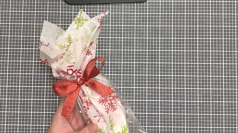 Snowflake tissue paper wrapped around a present and tied with a bow
