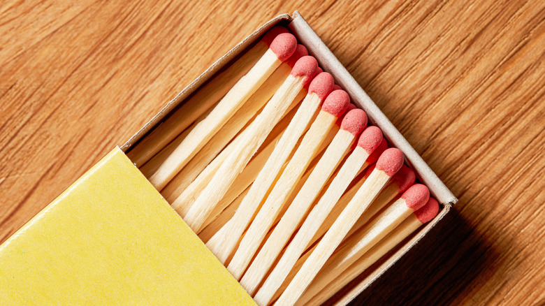 Matches in a match box on a wood tabletop.