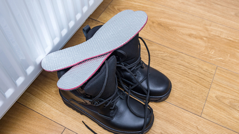 Metallic insoles sitting on top of winter boots.
