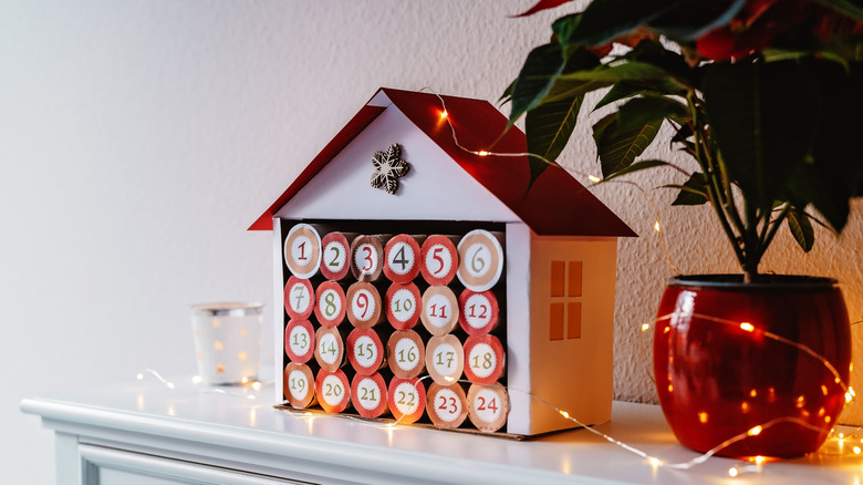 Cardboard house shaped advent calendar made with toilet rolls