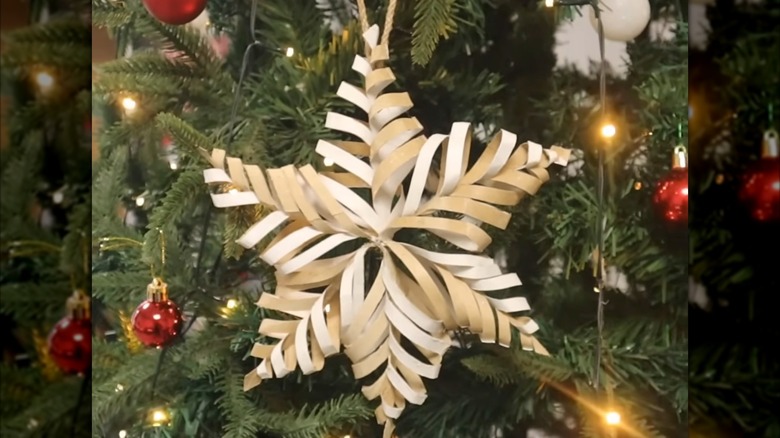 Toilet paper roll star ornament hanging on a Christmas tree