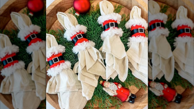 Four Santa napkin holders on a decorated tray