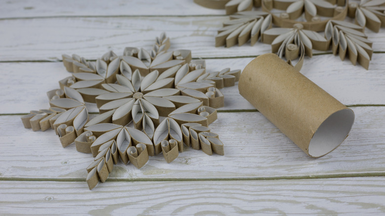 Intricate toilet paper roll snowflakes on a wood table
