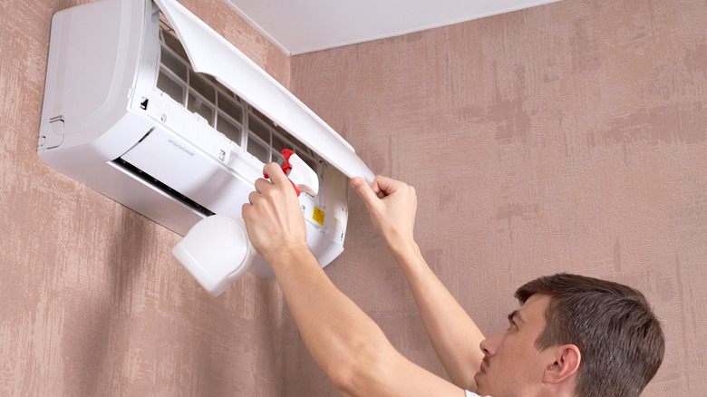 A person spraying an interior air conditioner unit