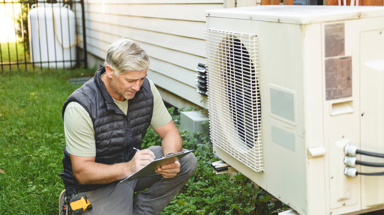 A professional technician working on an air conditioning unit
