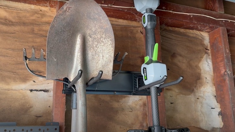 Wallavant tool organizer holding shovel, rake, and trimmer on garage wall