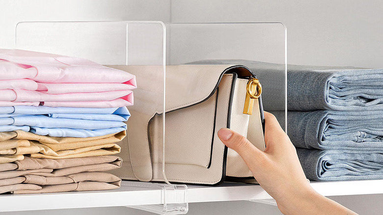 Close-up showing a person grabbing a handbag from a shelf organized with HBlife's Closet Shelf Dividers