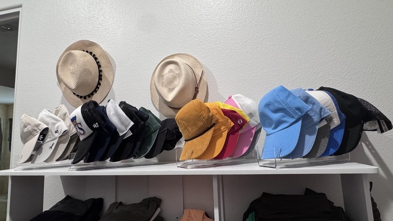 A collection of caps organized on a shelf with Sloworld's Hat Organizer