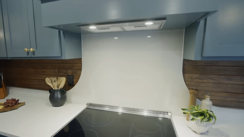 An ivory countertop with a wood panel backsplash.