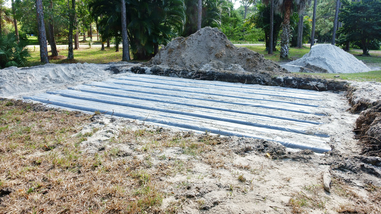 Septic drain system mid-installation, surrounded by piles of earth