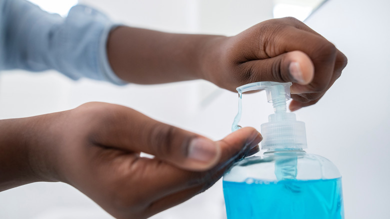 Person dispensing blue hand soap