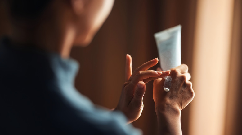 Woman applies lotion to hands