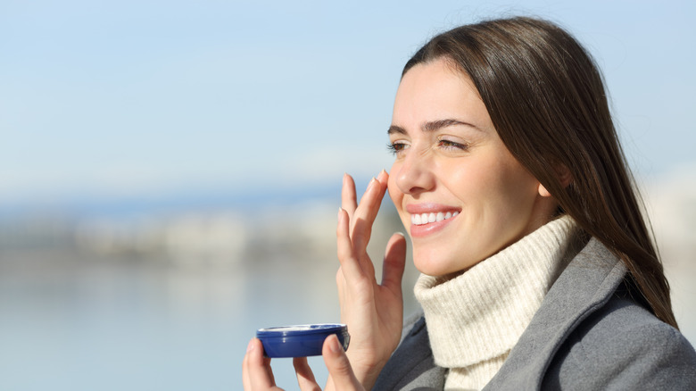 Woman applying sunscreen in winter
