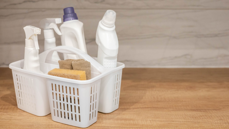 A plastic organizer holds bottles of cleaning supplies.