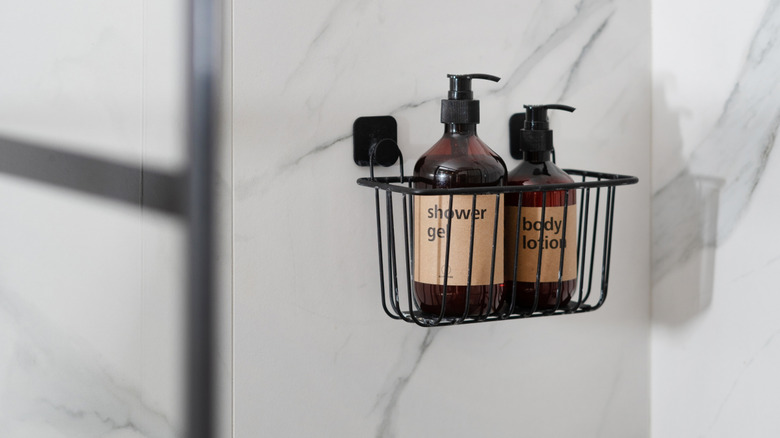A small black metal wire shower caddy in a shower stall.