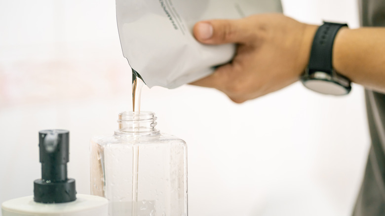 Person refilling a soap dispenser