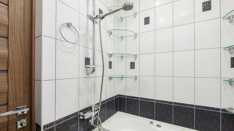 White shower with a line of black accent tile