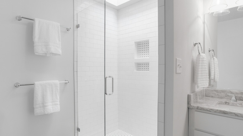All white bathroom with walk in shower and vanity