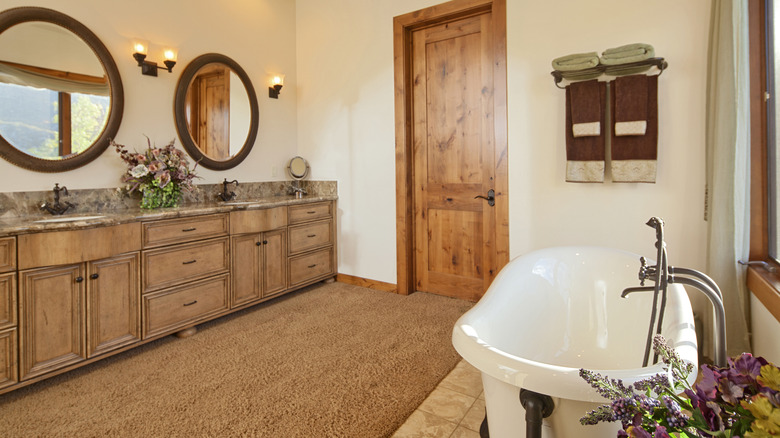Warm bathroom with natural wood tones and tan carpet