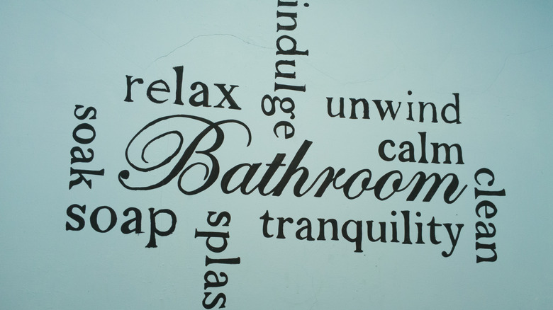 Word art on a blue bathroom wall.