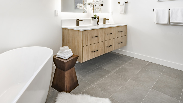 A  modern bathroom with large gray floor tiles.
