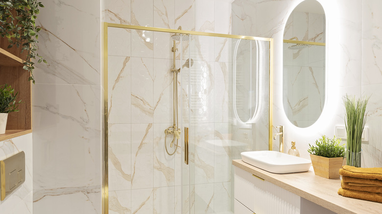 A bathroom with marble and gold accents