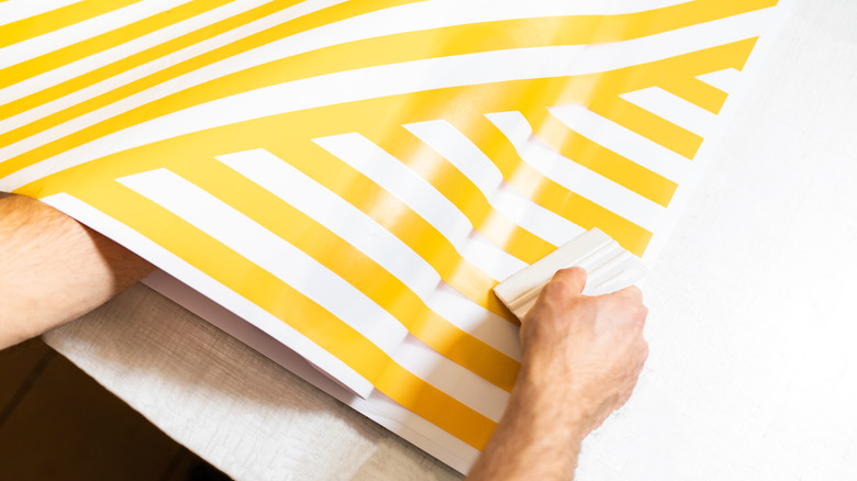 Person applying peel-and-stick wallpaper