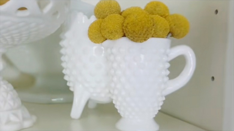 Bobnail milk glass pedestal creamer with dried billy button flowers inside