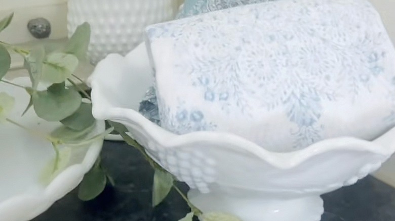 Folded fingertip towel inside a milk glass bowl