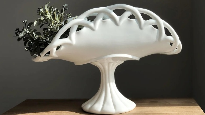 Milk glass banana stand with greenery on top