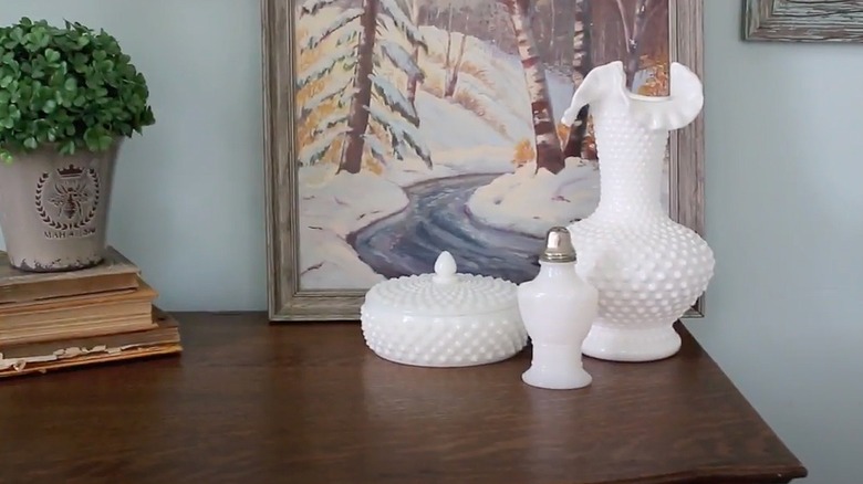 Milk glass pieces on a wooden entryway table