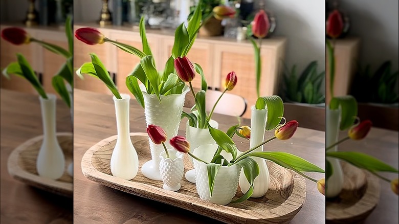 Arrangements of tulips inside various milk glass containers