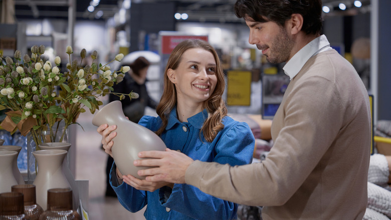 Couple admiring a vase while shopping