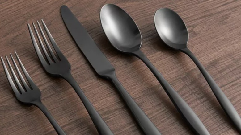 two forks, a knife, and two spoons from Cambridge Silversmiths Katerina Satin Flatware Set sitting on a wood surface