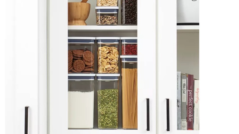 cabinet displaying OXO food storage containers stuffed with ingredients