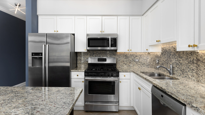 A kitchen with gray granite backsplash