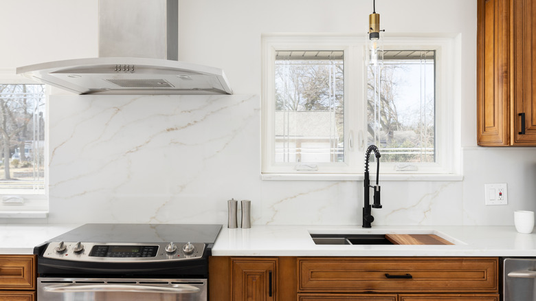 A kitchen with a white slab backsplash