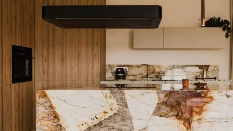 A modern kitchen with Patagonia quartzite brown and beige backsplash, counter, and island