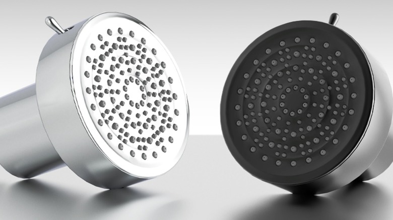 A chrome and a black shower head placed on a gray surface