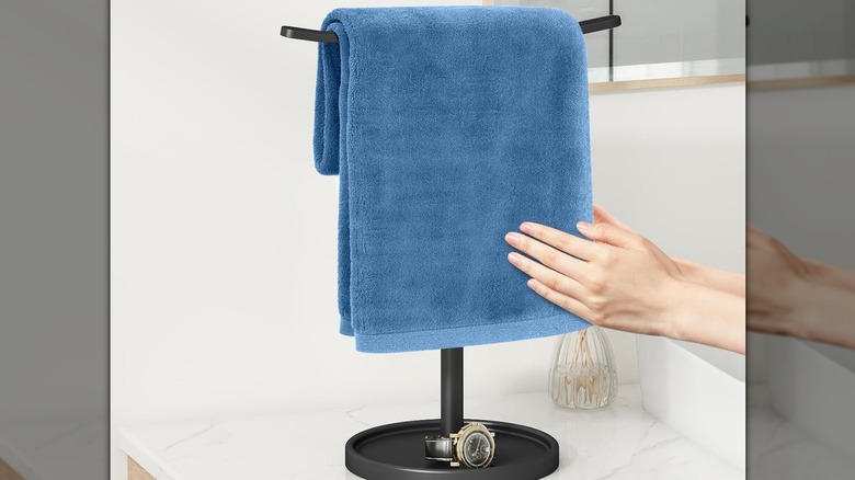 A blue hand towel draped over a T-shaped holder