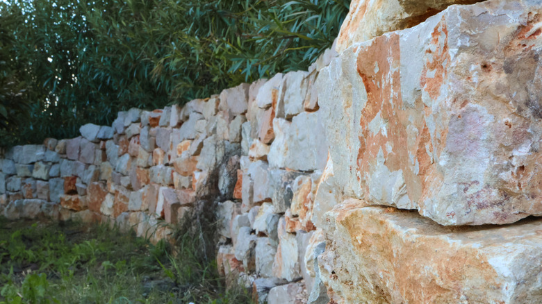Close up of reddish brown fieldstone wall in a garden