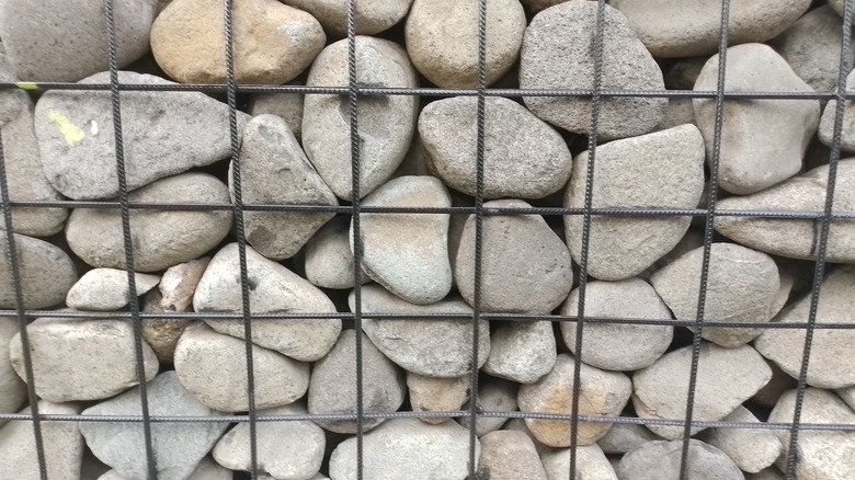 Close up photo of rocks stored in a gabion wall or wire container