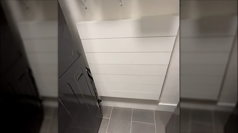 White box with large wooden panels attached to wall