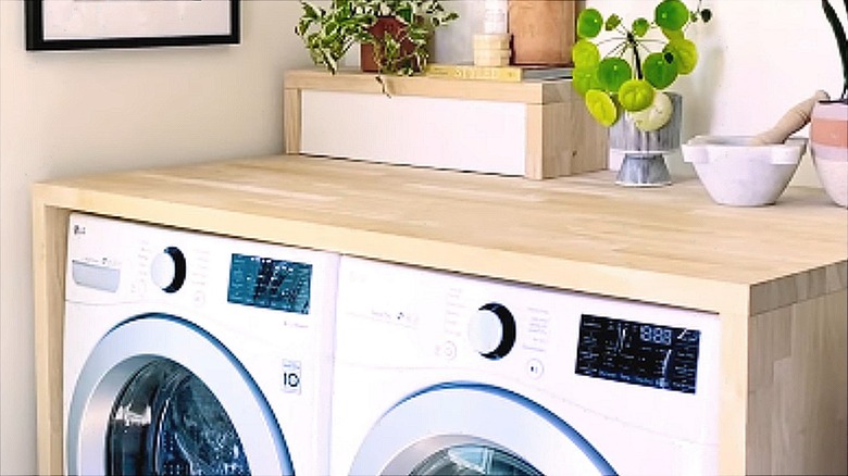 Wooden raised cover and countertop over washer and dryer