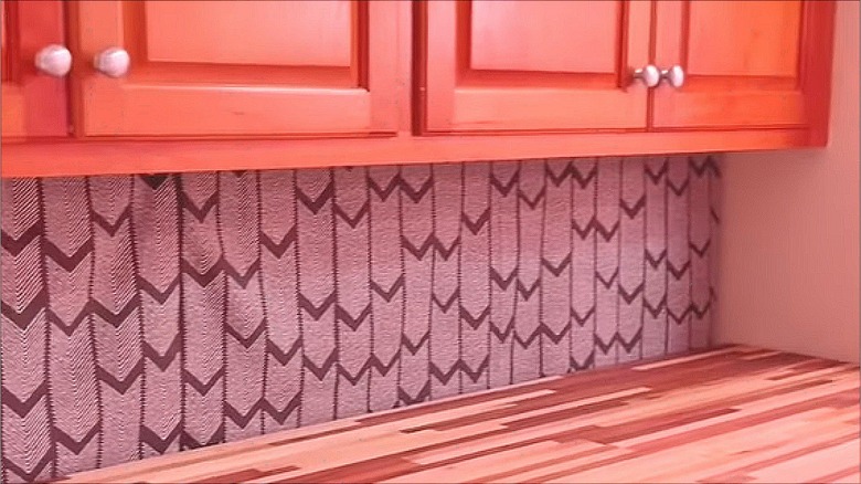 Curtains hanging under cabinet above washer and dryer set