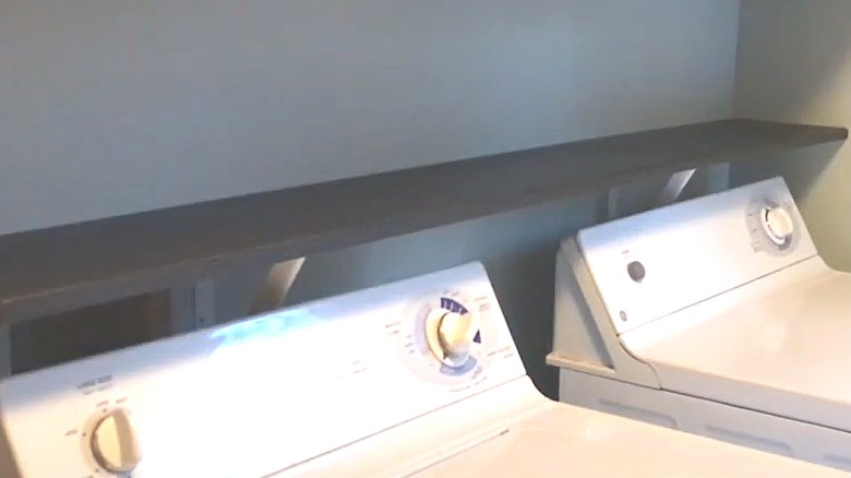 Black shelf above washer and dryer