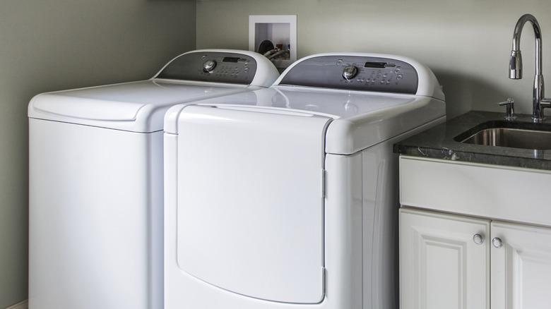 Washer and dryer in front of exposed washing machine hookups in wall