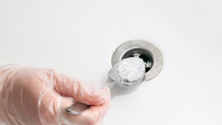 Pouring cleaner down a snk