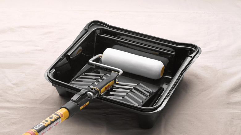 A Purdy roller in an empty black paint tray