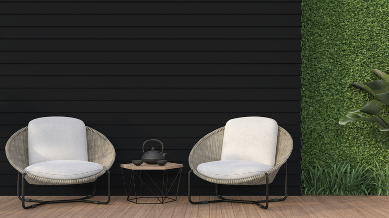 A garden patio wall painted black using a Ronseal paint product